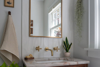 Inspiration for a mid-sized eclectic wainscoting powder room remodel in Portland with dark wood cabinets, white walls, an undermount sink, quartzite countertops and a freestanding vanity