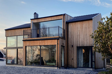 Ejemplo de fachada de casa gris y gris actual de tamaño medio de dos plantas con revestimiento de madera, tejado de teja de barro y tablilla