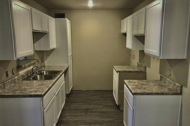 Mid-sized trendy galley eat-in kitchen photo in Other with shaker cabinets, white cabinets and laminate countertops