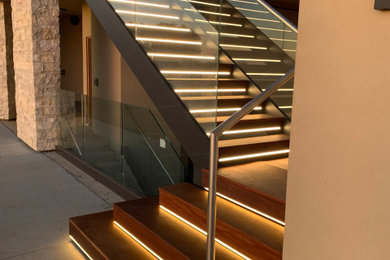 Foto de escalera en L moderna de tamaño medio con escalones de madera, contrahuellas de madera y barandilla de vidrio