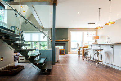 Minimalist medium tone wood floor living room photo in Vancouver with a two-sided fireplace and a stone fireplace