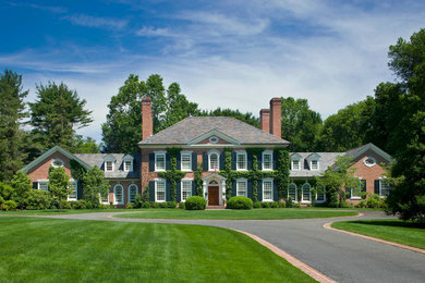 Large traditional red two-story brick house exterior idea in New York
