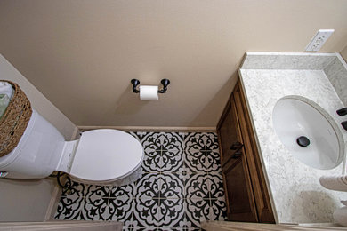 Example of a small transitional cement tile floor and blue floor powder room design in Cleveland with flat-panel cabinets, medium tone wood cabinets, a two-piece toilet, beige walls, an undermount sink, quartz countertops, white countertops and a built-in vanity