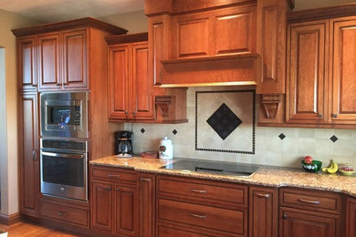 Eat-in kitchen - large traditional eat-in kitchen idea in Other with an undermount sink, raised-panel cabinets, brown cabinets, quartz countertops, stainless steel appliances and an island