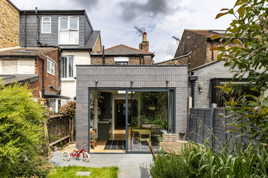 Inspiration for a small modern bungalow brick and rear house exterior in London with a flat roof.