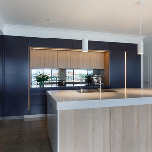 Inspiration for a large contemporary l-shaped kitchen pantry in Brisbane with a double-bowl sink, flat-panel cabinets, light wood cabinets, quartz benchtops, mirror splashback, black appliances, concrete floors, with island, multi-coloured floor and white benchtop.