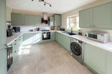 Large u-shaped ceramic tile and beige floor eat-in kitchen photo in Other with shaker cabinets, green cabinets, quartz countertops, white backsplash, stainless steel appliances, no island and white countertops