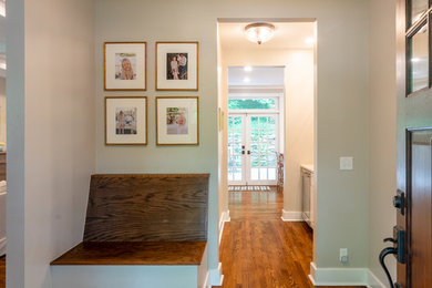 Mid-sized cottage medium tone wood floor entryway photo in Nashville with beige walls and a medium wood front door