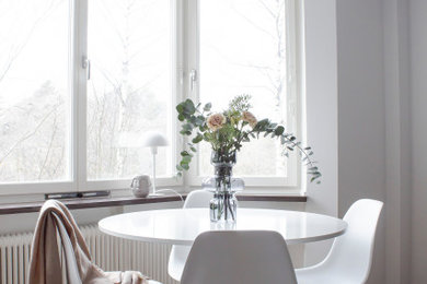 Photo of a small scandinavian open plan dining in Stockholm with white walls, light hardwood floors and beige floor.
