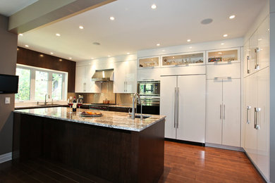 Inspiration for a mid-sized contemporary u-shaped medium tone wood floor eat-in kitchen remodel in Montreal with flat-panel cabinets, white cabinets, beige backsplash, subway tile backsplash, an island, granite countertops, paneled appliances and an undermount sink