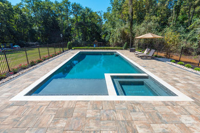 Example of a large minimalist backyard brick and rectangular lap hot tub design in New York