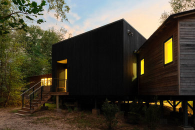 Mid-sized trendy one-story wood exterior home photo in Dallas with a metal roof