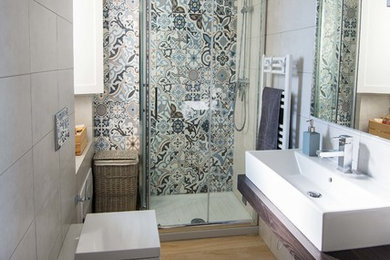 Idee per una piccola stanza da bagno con doccia contemporanea con WC sospeso, piastrelle blu, piastrelle in gres porcellanato, pavimento in gres porcellanato, lavabo rettangolare, top in legno, doccia ad angolo, pareti grigie, porta doccia scorrevole e top marrone