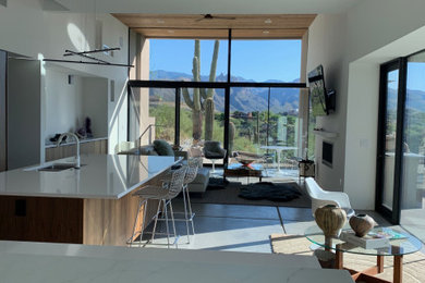 Large minimalist concrete floor and gray floor open concept kitchen photo in San Francisco with an undermount sink, flat-panel cabinets, medium tone wood cabinets, marble countertops, white backsplash, marble backsplash, paneled appliances, two islands and white countertops