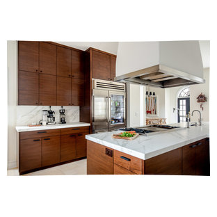 Design ideas for an expansive contemporary u-shaped kitchen pantry in Denver with a farmhouse sink, dark wood cabinets, beige splashback, stainless steel appliances, a peninsula, beige floor, flat-panel cabinets, marble benchtops, stone tile splashback, limestone floors and white benchtop.