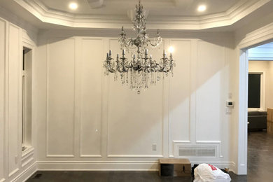 This is an example of a classic living room in Toronto with white walls, a coffered ceiling and wainscoting.