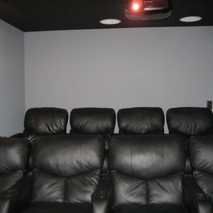 Home theater - mid-sized contemporary enclosed home theater idea in Manchester with white walls and a projector screen