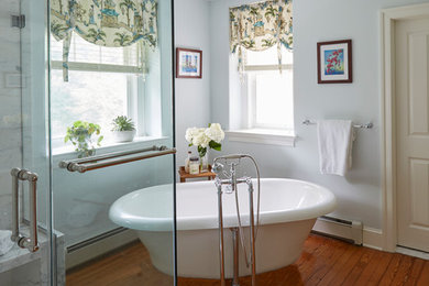 Inspiration for a large timeless master white tile and marble tile medium tone wood floor and brown floor bathroom remodel in Philadelphia with beaded inset cabinets, medium tone wood cabinets, a two-piece toilet, gray walls, an undermount sink, marble countertops and a hinged shower door