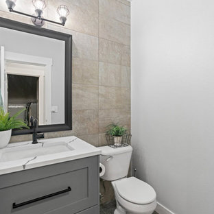Photo of a small modern 3/4 bathroom in Seattle with beaded inset cabinets, grey cabinets, a one-piece toilet, beige tile, ceramic tile, grey walls, cement tiles, an undermount sink, marble benchtops, black floor, white benchtops, a single vanity, a freestanding vanity and wallpaper.