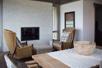 Sunroom - mid-sized contemporary medium tone wood floor and brown floor sunroom idea in Other with a standard fireplace and a standard ceiling
