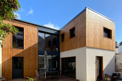 This is an example of a large and white contemporary terraced house in Nantes with three floors, wood cladding, a pitched roof, a metal roof, a grey roof and shiplap cladding.