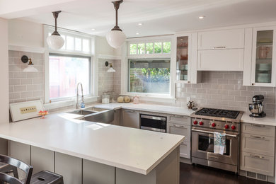Inspiration for a mid-sized eclectic u-shaped dark wood floor eat-in kitchen remodel in Other with a farmhouse sink, shaker cabinets, gray cabinets, quartz countertops, gray backsplash, subway tile backsplash, a peninsula and stainless steel appliances