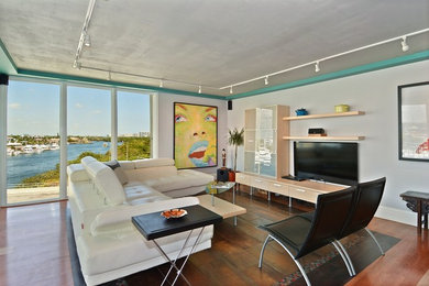 Inspiration for a contemporary open concept dark wood floor living room remodel in Miami with white walls and a media wall