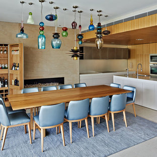 Idee per una grande sala da pranzo aperta verso il soggiorno minimal con pareti beige, camino lineare Ribbon, cornice del camino in pietra, pavimento beige e pavimento in pietra calcarea