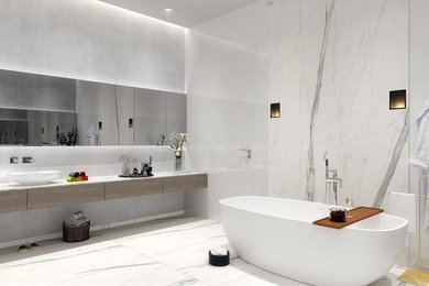 Large minimalist master multicolored tile and stone slab marble floor and multicolored floor freestanding bathtub photo in Miami with flat-panel cabinets, medium tone wood cabinets, multicolored walls, a vessel sink and marble countertops