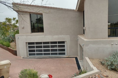 Photo of a contemporary grey house exterior in Phoenix with a flat roof and a tile roof.