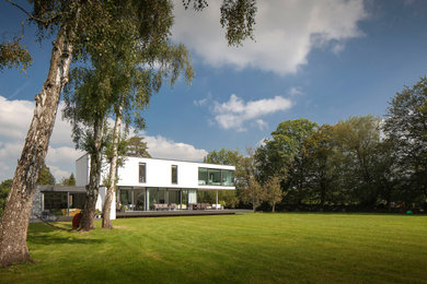Diseño de fachada de casa blanca minimalista de dos plantas con revestimiento de estuco y tejado plano
