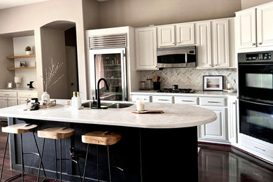 Imagen de cocina comedor moderna con puertas de armario blancas, una isla y encimeras blancas