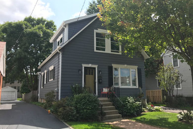 This is an example of a mid-sized traditional two-storey blue house exterior in Chicago with vinyl siding and a gable roof.