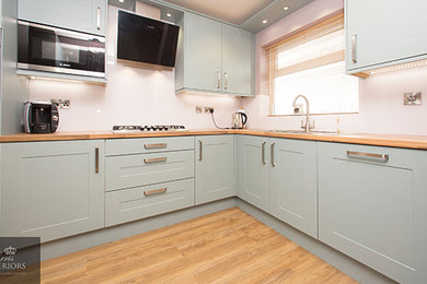 Design ideas for a large modern kitchen/diner in Other with laminate countertops, black appliances and laminate floors.