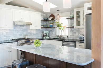 Inspiration for a transitional l-shaped dark wood floor eat-in kitchen remodel in Denver with an undermount sink, recessed-panel cabinets, white cabinets, quartz countertops, gray backsplash, ceramic backsplash, stainless steel appliances and an island