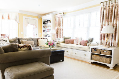 Design ideas for a traditional family room in Boston with yellow walls and light hardwood floors.