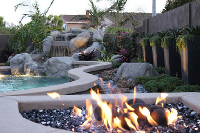 Inspiration for a mid-sized southwestern drought-tolerant and partial sun backyard stone landscaping in Orange County with a fire pit for summer.