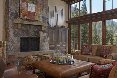 Family room - large rustic open concept medium tone wood floor family room idea in Sacramento with a standard fireplace, a stone fireplace, beige walls and a concealed tv