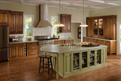 Example of a mid-sized classic l-shaped dark wood floor and brown floor eat-in kitchen design in Other with a double-bowl sink, raised-panel cabinets, dark wood cabinets, gray backsplash, stainless steel appliances and an island