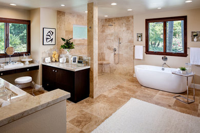 Design ideas for a large contemporary master bathroom in San Diego with flat-panel cabinets, dark wood cabinets, a freestanding tub, a curbless shower, a one-piece toilet, beige tile, stone tile, beige walls, travertine floors, an undermount sink and granite benchtops.