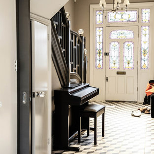 ロンドンの片開きドアトラディショナルスタイルのおしゃれな玄関ロビー (リノリウムの床、白いドア) の写真