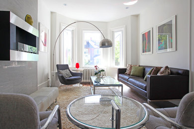 Inspiration for a large contemporary enclosed medium tone wood floor living room remodel in Toronto with white walls, a hanging fireplace, a tile fireplace and no tv