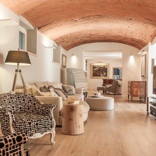 Großes, Offenes Mediterranes Wohnzimmer mit weißer Wandfarbe, hellem Holzboden, freistehendem TV und beigem Boden in Mailand