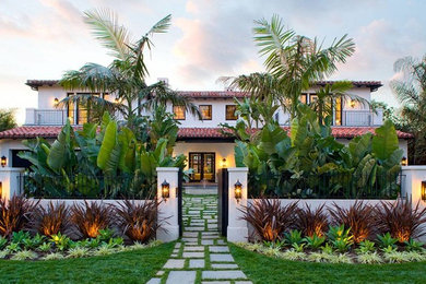 Inspiration for a mediterranean white two-story house exterior remodel in Los Angeles with a hip roof and a tile roof