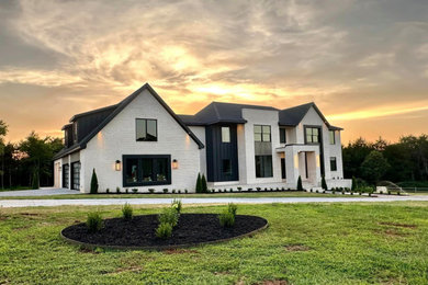 Inspiration for a large modern white two-story brick house exterior remodel in Other with a shingle roof and a black roof