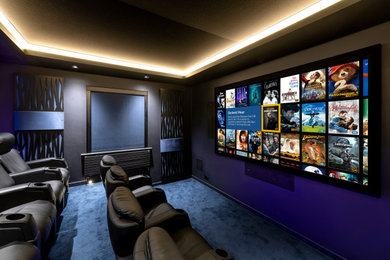 Modelo de cine en casa moderno pequeño con paredes azules, moqueta, pantalla de proyección y suelo azul