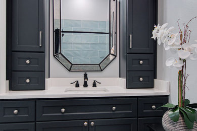 Mid-sized eclectic blue tile ceramic tile, multicolored floor and single-sink bathroom photo in New Orleans with recessed-panel cabinets, blue cabinets, an undermount sink, quartzite countertops, white countertops and a built-in vanity