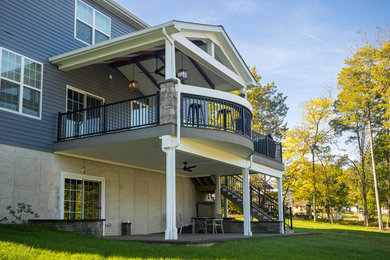 Mid-sized minimalist concrete metal railing back porch photo in Philadelphia with a roof extension