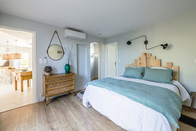 Idées déco pour une chambre parentale scandinave de taille moyenne avec un mur gris, parquet clair et aucune cheminée.