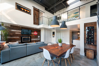 Inspiration for an industrial concrete floor great room remodel in Vancouver with white walls